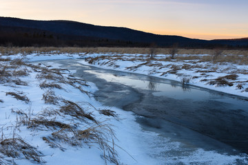 Frozen Stream and Snow Covered Field at Sunset