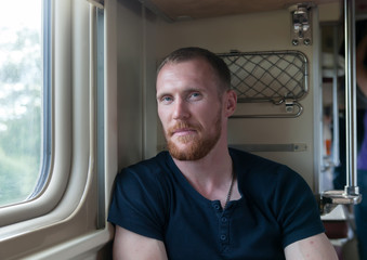 Portrait of   young man at  train window.