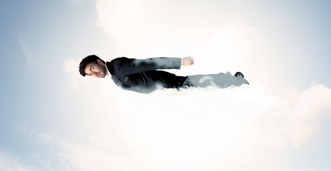 Business man flying like a superhero in clouds on the sky