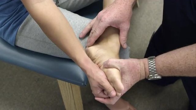 Therapist working on patient's foot and ankle.