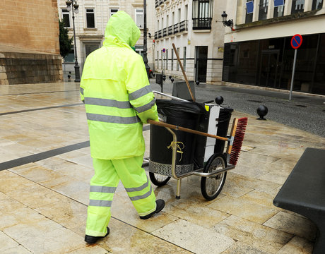 Barrendero trabajando bajo la lluvia