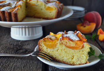 Delicate cake with peaches, dusted with icing sugar