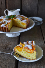 Delicate cake with peaches, dusted with icing sugar