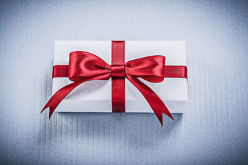 Present box with tied bow on white background holidays concept