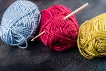 Colorful  yarn skeins on wooden background.