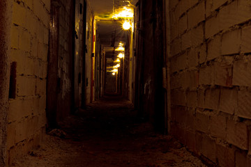 Fototapeta na wymiar gloomy tunnel poorly lit with lots of rusty door
