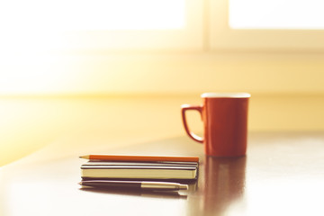 Naklejka premium Notepads and pens with cup of hot drink