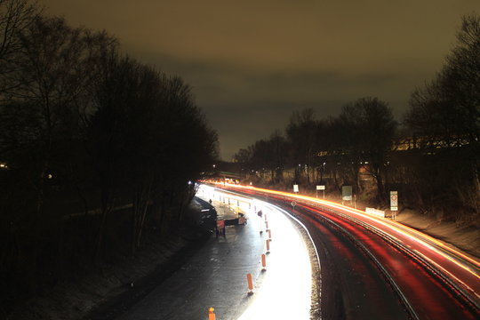 Autobahn, Nachts, nach Regen an einer Baustelle mit B&auml;umen an der Seite.