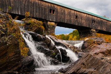 Wooden Covered Bridge Over Waterfalls in Autumn