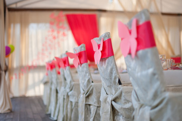 chairs in white covers with a red ribbon