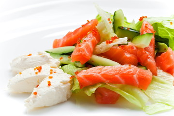  Delicious salmon salad with cucumber, mozzarella and caviar close up on white background 