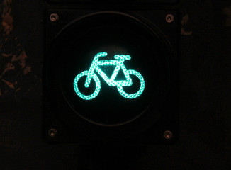 Green colored traffic light with bike sign for cyclists close up