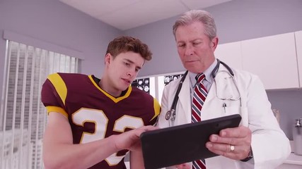 Young adult sports athlete looking at sports injury on tablet computer - Powered by Adobe