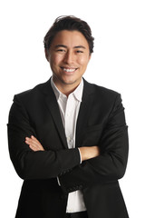 An attractive businessman wearing a black suit with a white shirt, standing against a white background with his arms crossed.