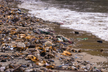 Beach pollution. Plastic bottles and other trash on sea beach