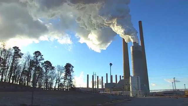 A coal fired power plant belches smoke into the air.