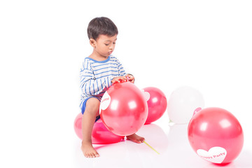 happy cute little boy play with red balloon