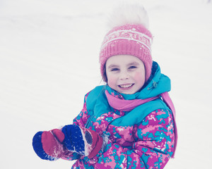 Happy kid winter day playing in the snow. 