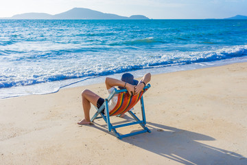 Fototapeta na wymiar Man relaxing on beach, ocean view