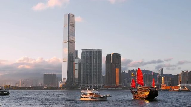 Wooden sailboat in Hong Kong harbor at evening twilight. Asia landmark cruise