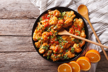 orange chicken on a plate on the table. Horizontal top view, rustic
