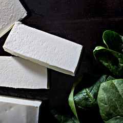 Fresh spinach and feta cheese on a black background