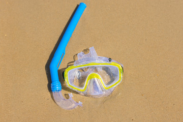 The swimming mask and snorkel to breathe under water, lie on the wet sand at the sea coast