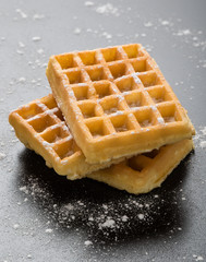 sugary waffles on black table