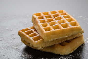 sugary waffles on black table