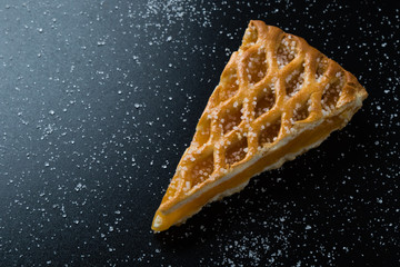 apple pie slice on black table with sugar