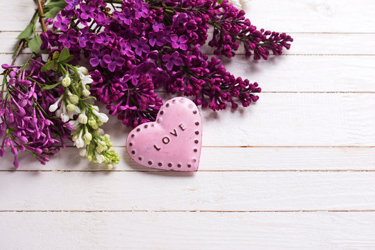 Fresh white and violet lilac flowers and decorative pink heart