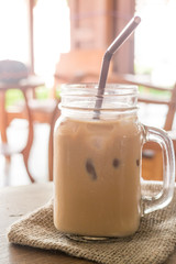 Iced milk coffee glass on wooden table with vintage filter effec