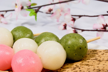 竹笹に載せられた三色団子とソメイヨシノ 