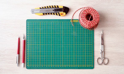 Desktop mockup, top view, with colorful stationery and cutting mat, on wooden background