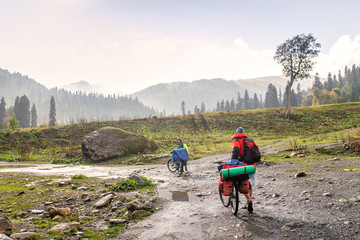 Two bikers on the road in mountains after rain, National park