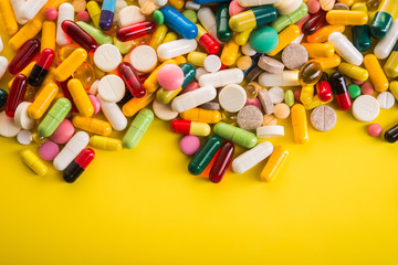 Colored pills on yellow background