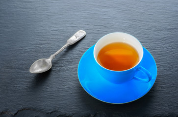 Tea in blue cup and a teaspoon