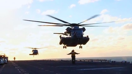 Helicopters land on the deck of an aircraft carrier during search and rescue operations of Hurricane Sandy.