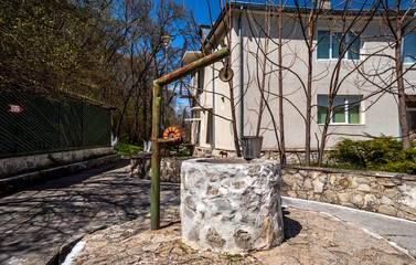 Traditional Romanian fountain with water bucket at St Andrew's Monastery ,Romania