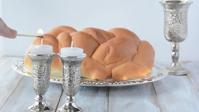 Jewish woman hand lights Shabbat candles