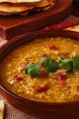 .Thick indian red lentil soup with cilantro served with indian f