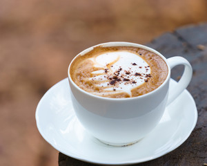 Cup of Cappuccino on wooden  table with chocolate.