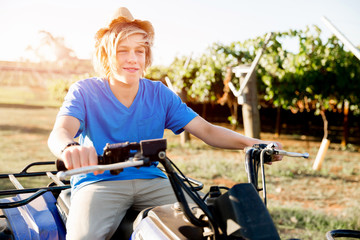Boy riding farm truck in vineyard