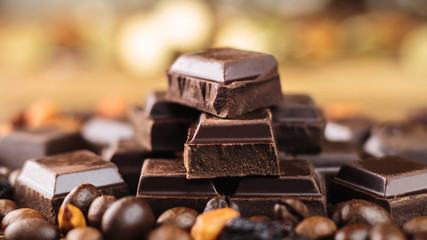 Dark chocolate cubes, coffee beans and peanuts, close-up, soft, selective focus