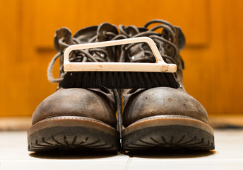 Cleaning brush and leather boots close-up