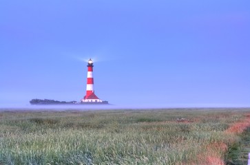 Westerhever Leuchtturm im Nebel und Sonnenaufgang