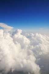 Fluffy white clouds and blue sky seen from airplane