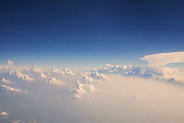 Naklejka na ściany i meble Fluffy white clouds and blue sky seen from airplane