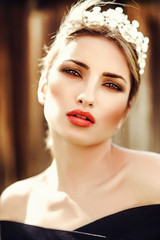 Beautiful girl model blonde summer outdoors in the crown. Red lips, manicure, smoky eyes. photo art, soft focus.