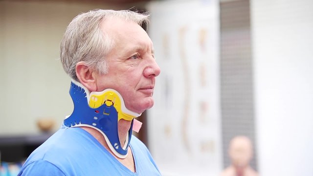 A mature patient wearing a spine collar. This brace gives shelter to the cervical spine after accident. 
